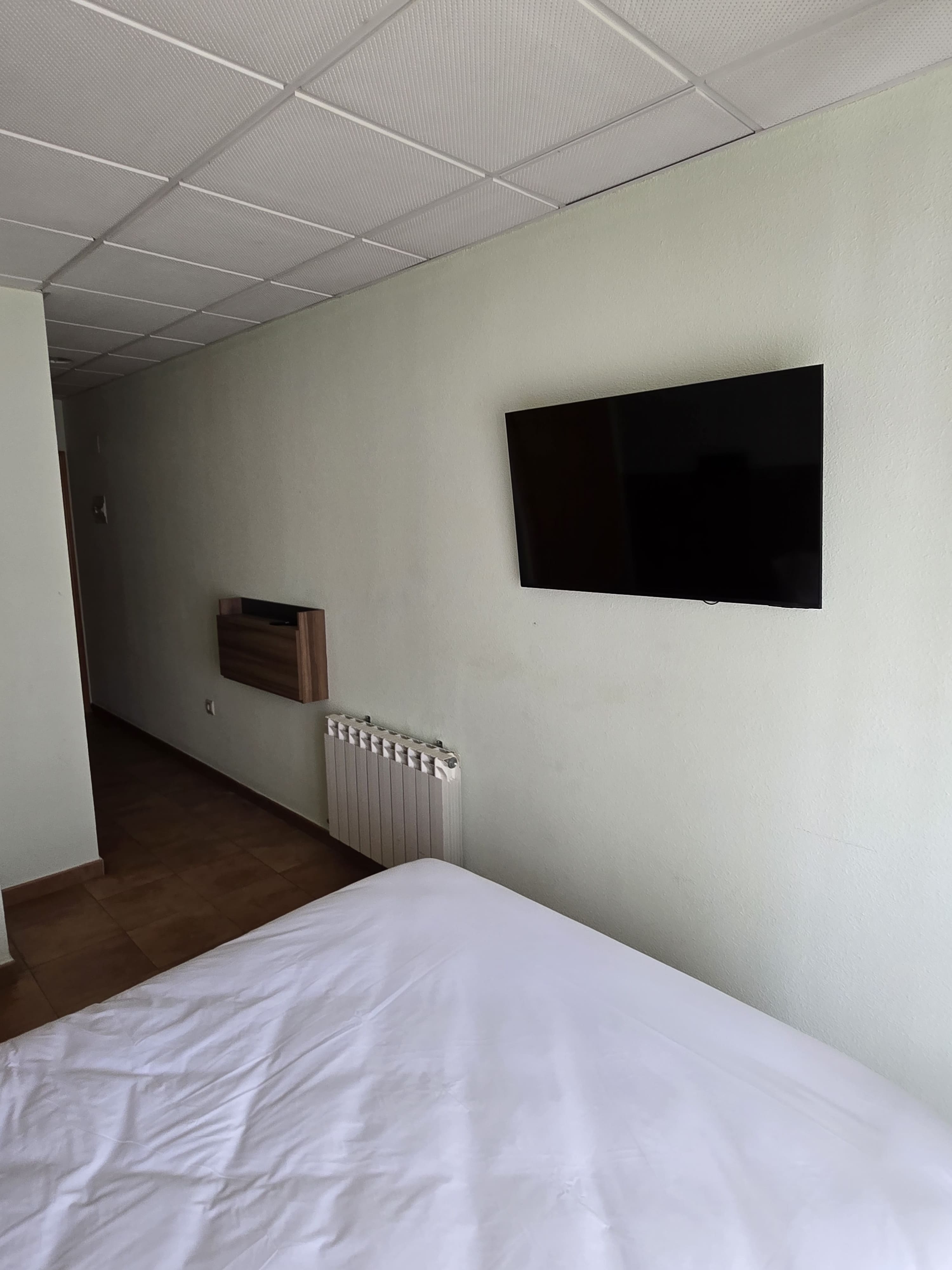 Cama matrimonial con luz natural en habitación doble económica